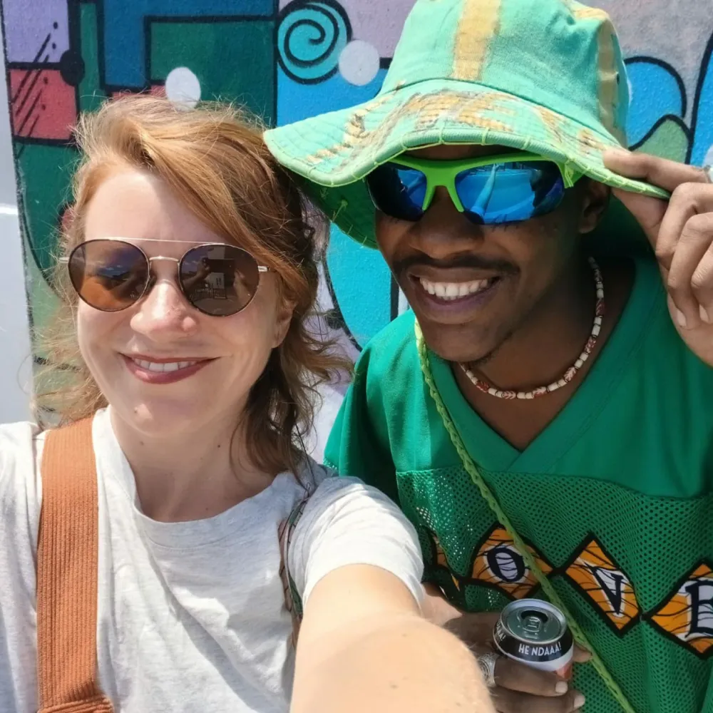 Guest and Masande taking a selfie at a mural