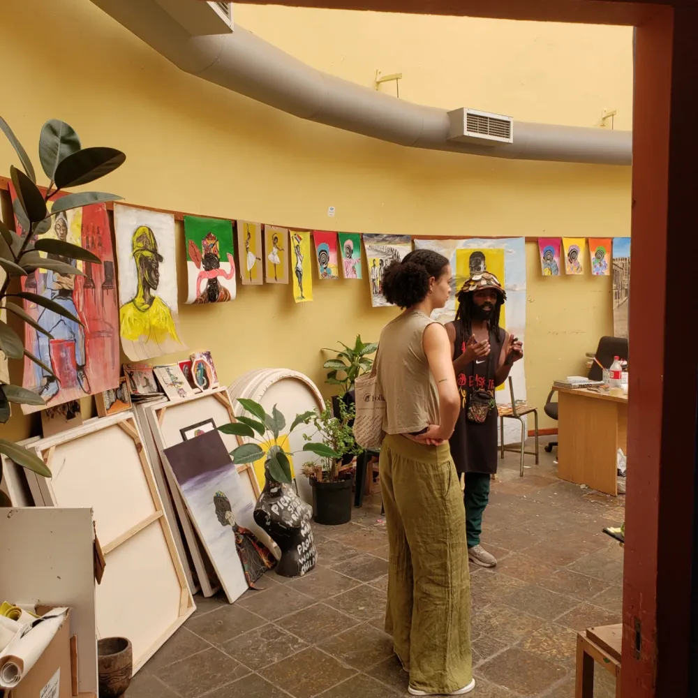 Masande explaining artworks in a studio