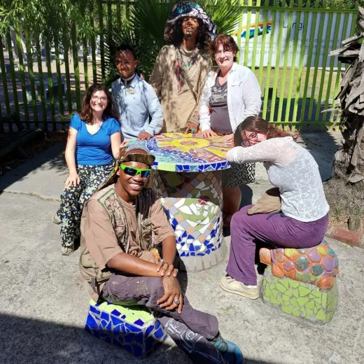 Tour group around the mosaic table at Guga S'thebe