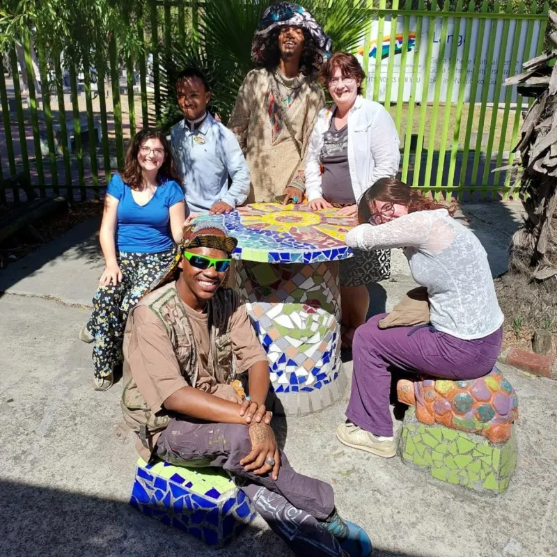 Tour group around the mosaic table at Guga S'thebe