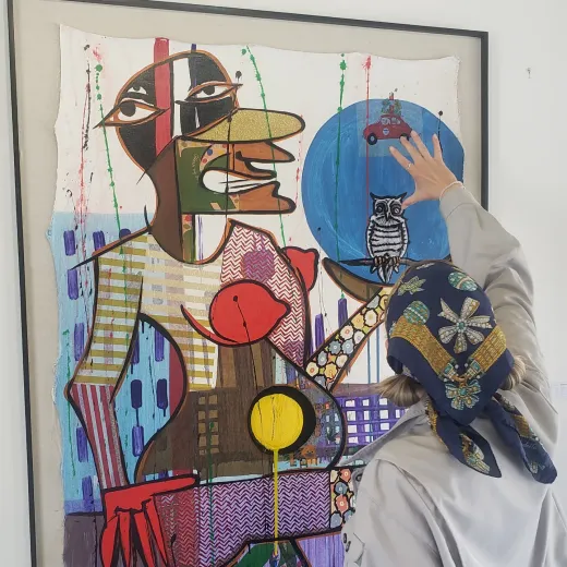 Visitor looking at a framed painting in the gallery